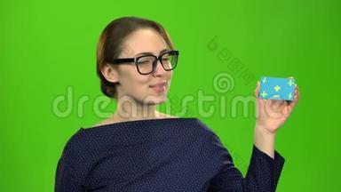 女孩宣传一张卡片，竖起大拇指。 绿色屏幕